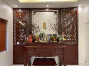 Bàn thờ gia tiên ngày Tết với hai bình hoa đào cắm cân đối hai bên và mâm ngũ quả ở giữa