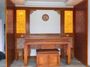 Phòng thờ gỗ tự nhiên với chữ Phúc treo giữa vách ốp, hai bên là tranh trúc chỉ và vách CNC hoa văn